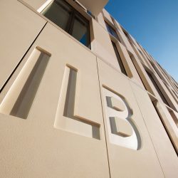 Detail der Fassade des ILB-Gebäudes. Eingefräst in die Fassadenverkleidung sind die Logo-Buchstaben ILB.