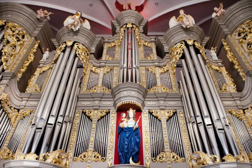 Historische Orgel mit vielen Orgelpfeifen im Dom von Kaliningrad. Das Instrument ist mit goldenen Ornamenten, musizierenden Engeln sowie einer sakralen Statue verziert.