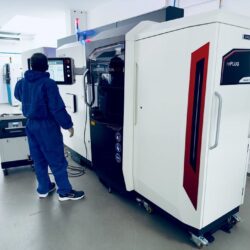 Ein Arbeiter steht vor einer hochmodernen 3D-Druckmaschine