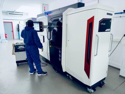 Ein Arbeiter steht vor einer hochmodernen 3D-Druckmaschine