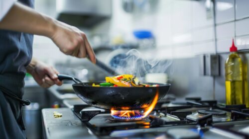 Ein Koch kocht mit Dampf und Flammen