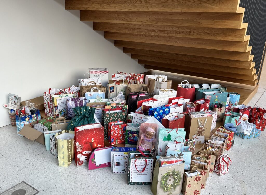 Eine große Anzahl Weihnachtstüten mit Geschenken steht auf dem Boden.